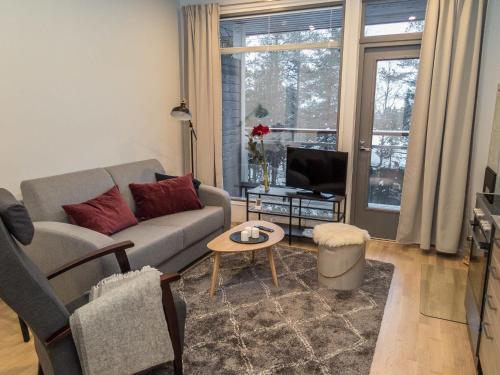 een woonkamer met een bank en een tv bij Holiday Home Ylälänsi 3 as 11 by Interhome in Ylläsjärvi