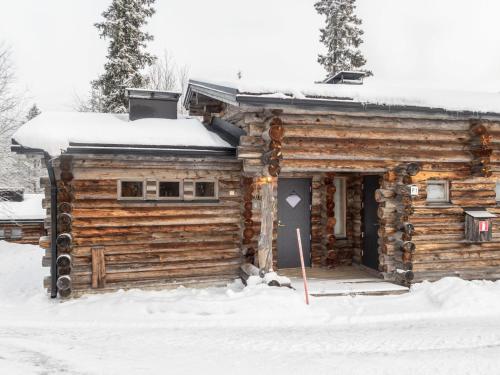 ein Blockhaus mit einer Tür im Schnee in der Unterkunft Holiday Home Salmikangas f1 by Interhome in Ruka