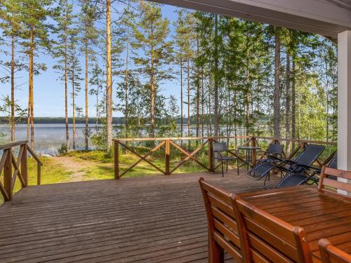 a deck with chairs and a table and a view of a lake at Holiday Home Kaarna by Interhome in Pertunmaa