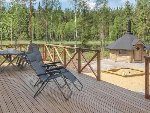 a deck with a chair and a table and a gazebo at Holiday Home Kurki by Interhome in Pertunmaa