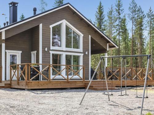 a house with a porch and a porch swing at Holiday Home Kurki by Interhome in Pertunmaa