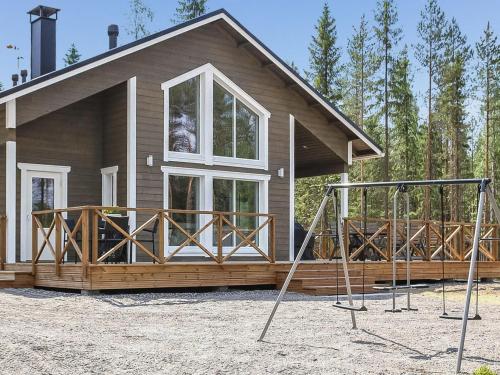ein Haus mit einer Veranda und einer Hollywoodschaukel in der Unterkunft Holiday Home Kurki by Interhome in Pertunmaa