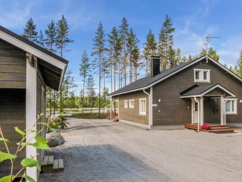 a building with a garage next to a forest at Holiday Home Kielo by Interhome in Pertunmaa