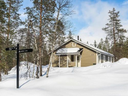 eine Hütte im Schnee mit einem Schild davor in der Unterkunft Holiday Home Aarre a by Interhome in Saariselkä