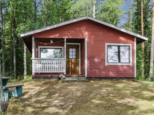 a red tiny house in the middle of the forest at Holiday Home Haapalehto by Interhome in Nurmes