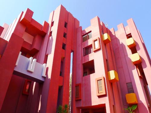 un edificio con facciate rosse e bianche e un cielo blu di Studio Muralla Roja-3 by Interhome a Calpe