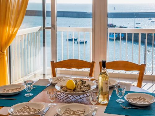 - une table avec une assiette de nourriture et une bouteille de vin dans l'établissement Apartment Port Maria-2 by Interhome, à Quiberon