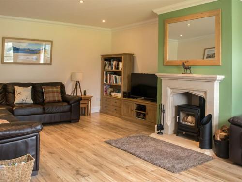 a living room with a couch and a fireplace at Holiday Home Strath Glebe by Interhome in Broadford