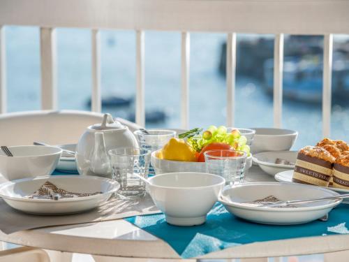 une table avec des assiettes et des bols de nourriture dans l'établissement Apartment Port Maria-2 by Interhome, à Quiberon