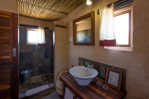 a bathroom with a sink and a shower at Wilderness Safaris Kulala Desert Lodge in Sesriem