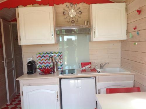 a kitchen with white cabinets and a sink at la roulotte arc-en-ciel in Villards-dʼHéria