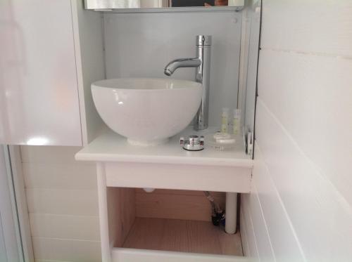 a bathroom sink with a white bowl sink at la roulotte arc-en-ciel in Villards-dʼHéria