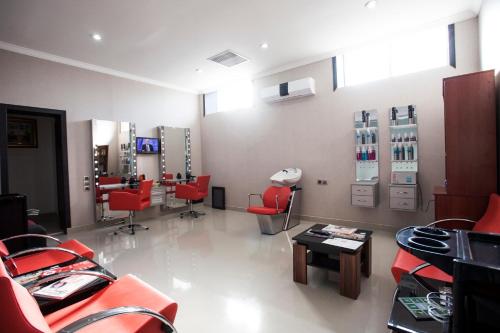 a hair salon with red chairs and a waiting room at Gashalti Health Hotel Naftalan in Naftalan