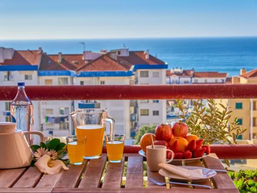 una mesa con fruta y bebidas en el balcón en Apartment vista oceano by Interhome, en Ericeira