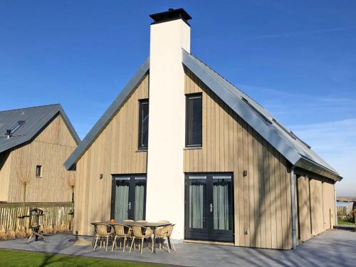 a barn with a table and chairs in front of it at Holiday Home Oesterdam Resort-1 by Interhome in Tholen