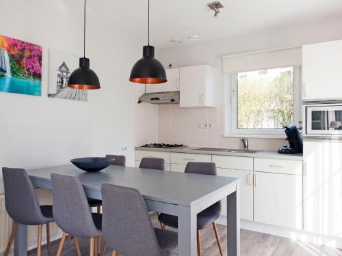 a kitchen with a dining room table and chairs at Holiday Home Bungalowpark It Wiid by Interhome in Eernewoude