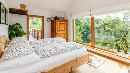 um quarto com uma cama e uma grande janela em Ferienhaus Riegelnegg em Oberhaag