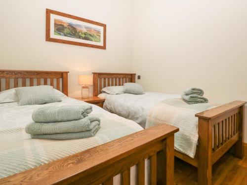 a bedroom with two beds with towels on them at Little Crake Howe in Grayrigg