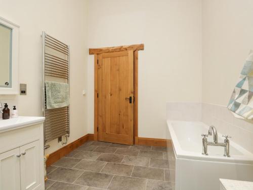 a bathroom with a sink and a tub and a toilet at Little Crake Howe in Grayrigg