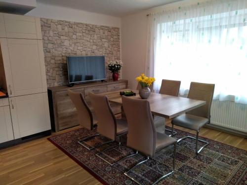 a dining room with a table and chairs and a television at Penzion Milada in Všetaty