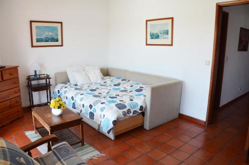 ヴィラ・ノヴァ・デ・ミルフォンテスにあるApartamentos Cintra do Valeのテーブル付きの部屋にベッド付きのベッドルームがあります。