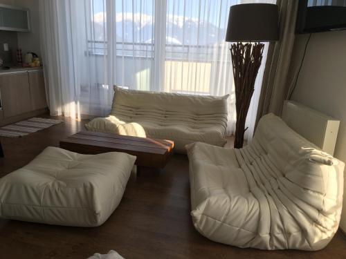 una sala de estar con 2 sofás blancos y una mesa. en Triangel 215 en Donovaly
