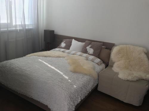 un perro blanco acostado en una cama en un dormitorio en Triangel 215 en Donovaly