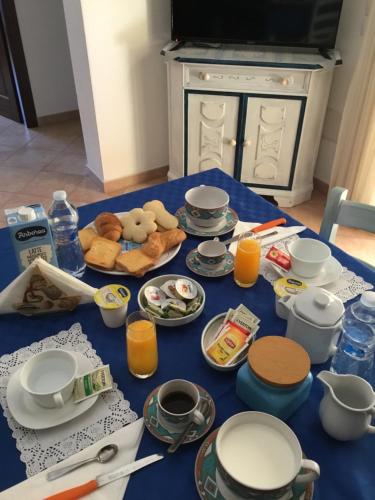 a table with a blue table cloth with food on it at B&B Levante Posada in Posada