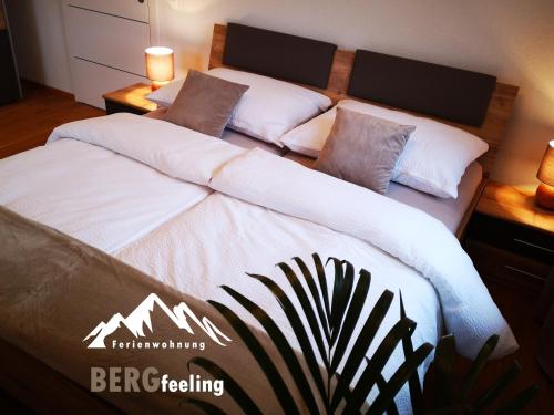 sypialnia z 2 łóżkami z białą pościelą i poduszkami w obiekcie Ferienwohnungen BERGfeeling w mieście Bad Mitterndorf