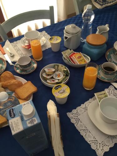 a blue table with breakfast foods and orange juice at B&B Levante Posada in Posada