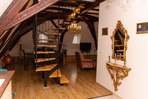 a living room with a staircase leading up to a dining room at L'ambassadeur - Colmar centre in Colmar