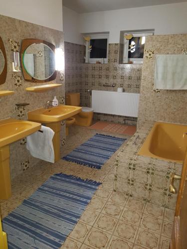 a bathroom with two sinks and a tub and a mirror at Eventgasthaus Greil in Leitzersdorf