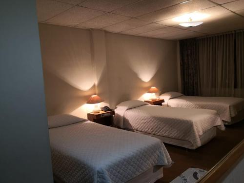 a hotel room with two beds and two lamps at Gran Hotel Ambassador in Cochabamba