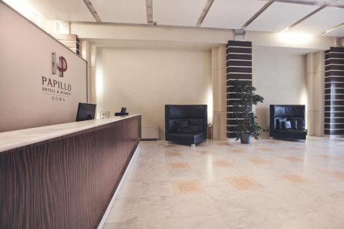 a lobby with a counter and chairs in a building at Papillo Hotels & Resorts Roma in Rome