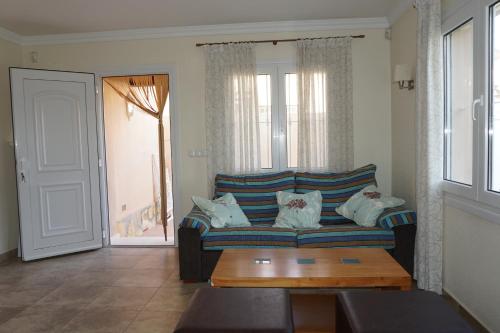 ein Wohnzimmer mit einem blauen Sofa und einem Tisch in der Unterkunft Golf & Playa II in Oliva