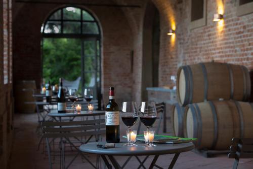 een tafel met een fles wijn en wijnglazen bij Marchesi Alfieri - Cantine e Ospitalità in San Martino Alfieri