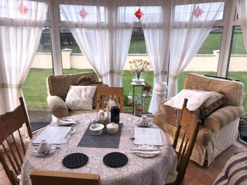 a dining room with a table and chairs and a window at Lisnagalt Lodge in Coleraine