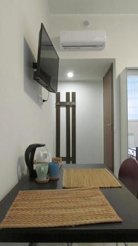 a room with a table with a television and a table sidx sidx at SanSiroFiera Rooms in Milan