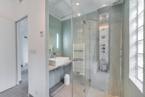 une salle de bain avec un lavabo et une douche dans l'établissement Villa Gaïa, à Saint-Tropez
