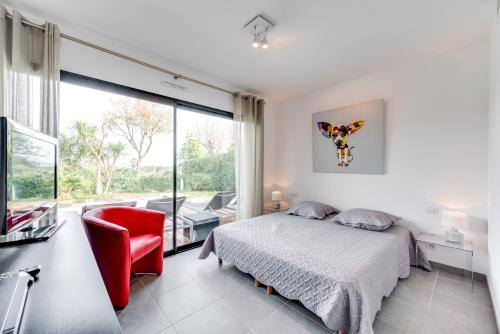 une chambre avec un lit et une chaise rouge dans l'établissement Villa Gaïa, à Saint-Tropez