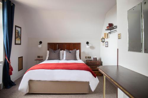 a bedroom with a bed with a red and white blanket at The Bath Hotel in Lynmouth