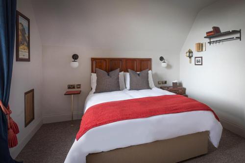 a bedroom with a large bed with a red blanket at The Bath Hotel in Lynmouth
