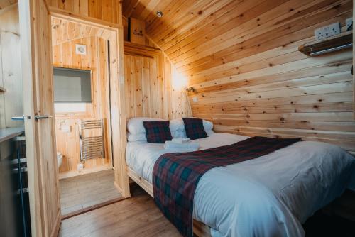 ein Schlafzimmer mit einem Bett in einer Holzhütte in der Unterkunft North Coast 500 Pods in Achmelvich