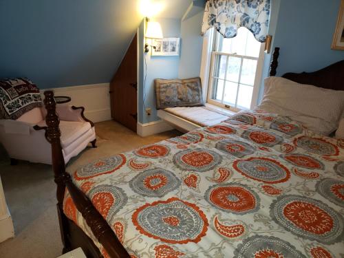 a bedroom with a bed with a quilt on it at English Cottage in Greensboro