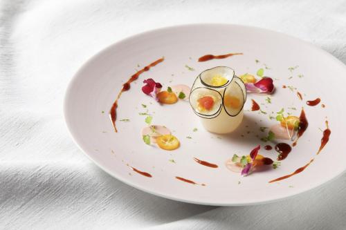 a plate of food with a drink on a table at Relais & Châteaux La Maison Des Têtes in Colmar