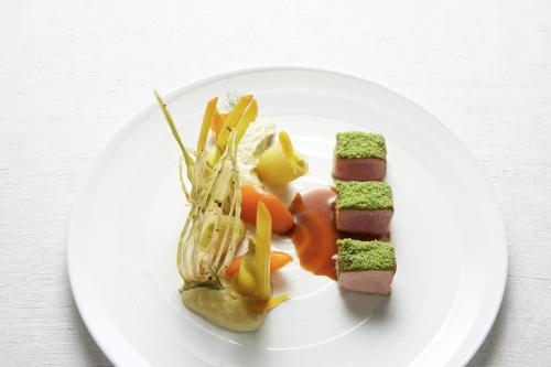 a plate of food with meat and vegetables on it at Relais & Châteaux La Maison Des Têtes in Colmar