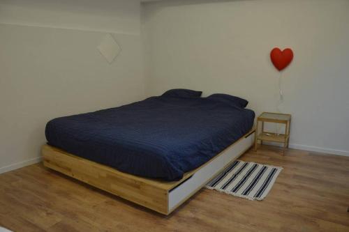 ein Bett in einem Schlafzimmer mit einem Herzballon an der Wand in der Unterkunft Top Studio Marolles in Brüssel