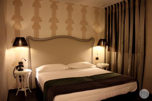 アルクァ・ペトラルカにあるLocanda Viridariumのベッドルーム1室(ベッド1台、テーブル2台、ランプ2つ付)