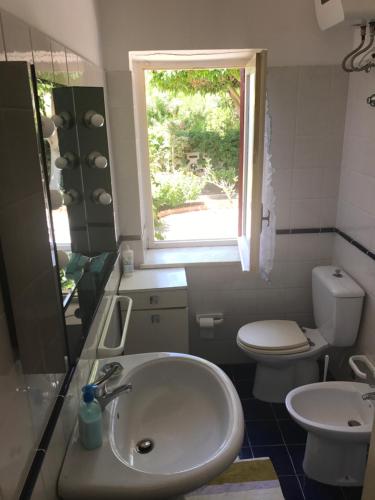 貝爾韋代雷的住宿－Villa Sasà，一间带水槽和卫生间的浴室以及窗户。