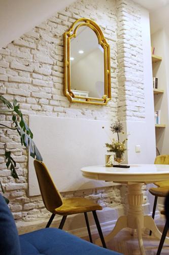 a dining room with a table and a mirror at Apartments Satva in Vilnius